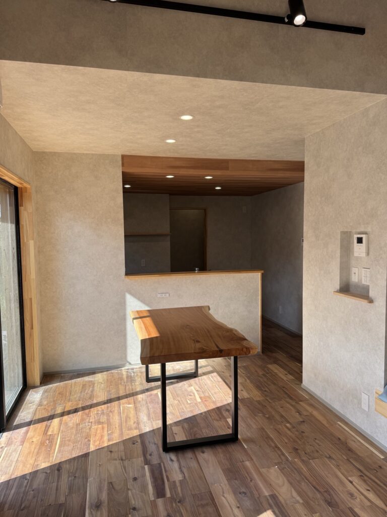 アカシア無垢床の上に置かれた一枚板ダイニングテーブルとリビング空間