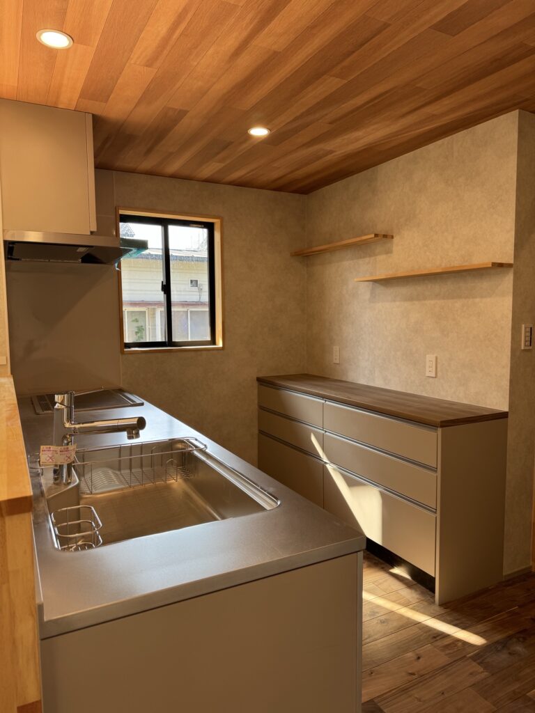 木目天井とグレーカラーのキッチンが調和した八女市の注文住宅キッチン
