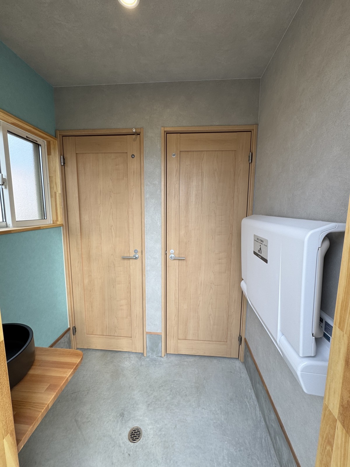 福岡県久留米市うるう農園の女性用新築トイレ入口。おむつ交換台を備えた子連れに配慮したトイレ空間。