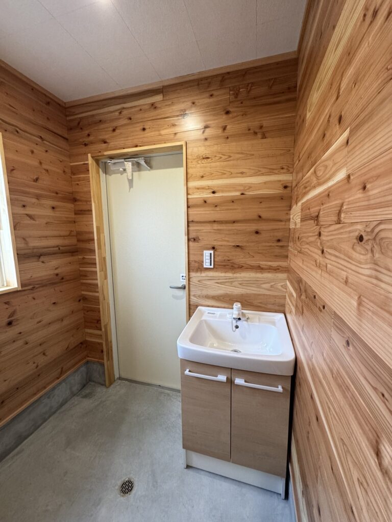 うるう農園の男性用新築トイレの手洗いスペース。木の内装と使いやすさを両立したトイレ空間