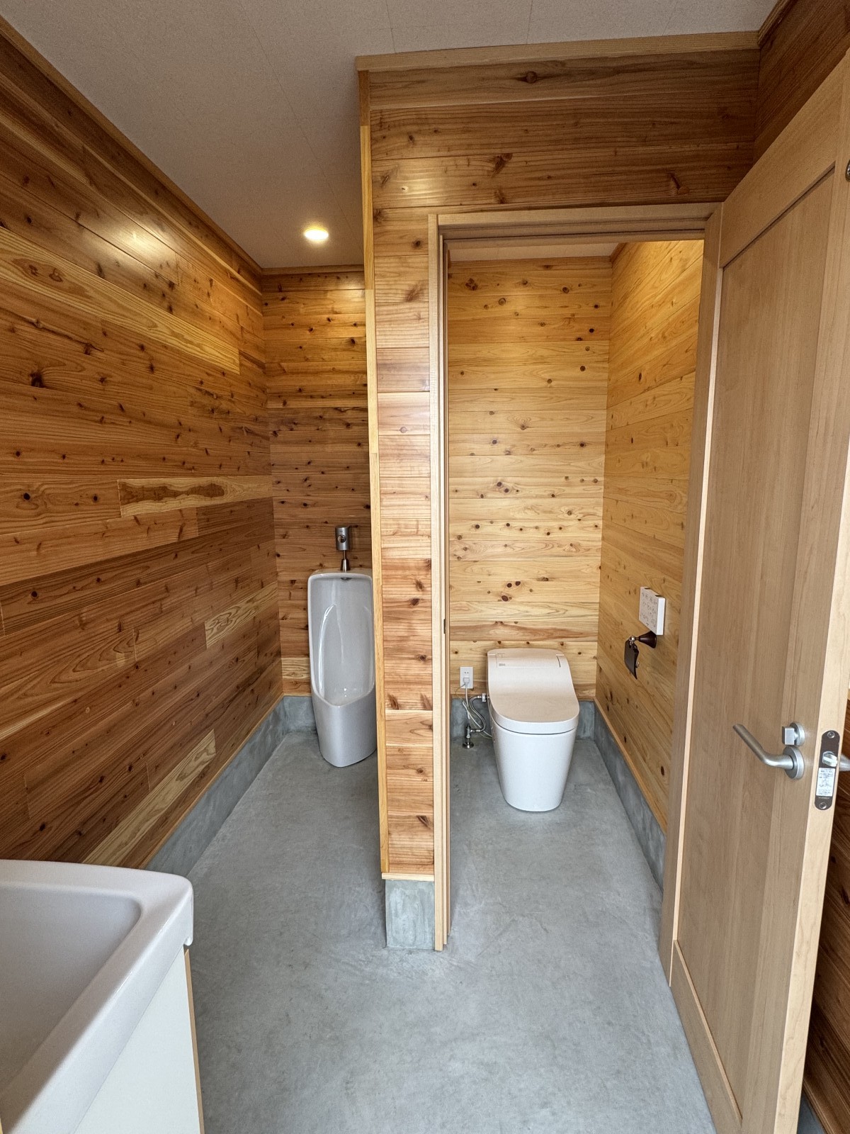 久留米市うるう農園の男性用トイレ個室。自然素材に囲まれたあたたかみのある新築トイレ施工事例