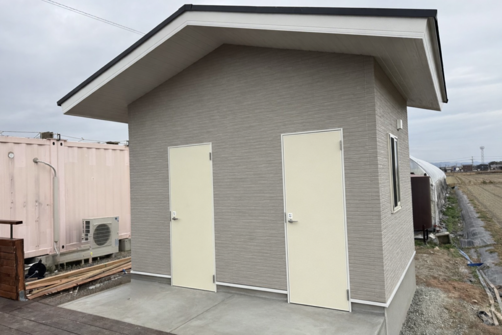 福岡県久留米市のうるう農園に新築したトイレ棟の外観。男女別の出入口を備えたシンプルで使いやすい建物
