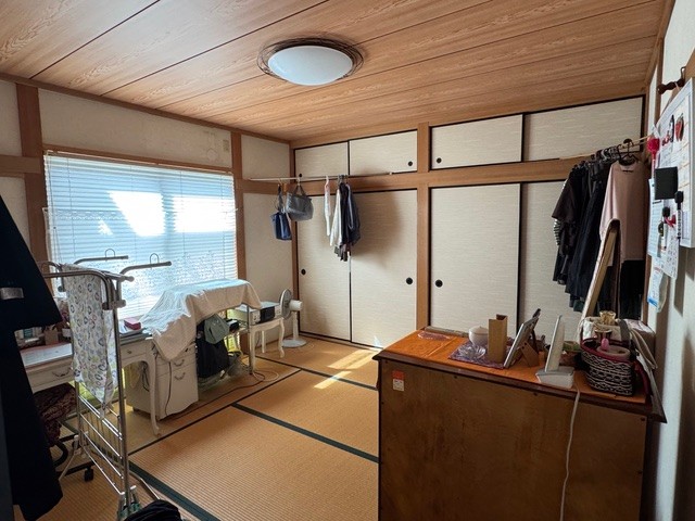 和室リフォームのBefore写真：窓際に家具や衣類が置かれ生活感のある畳の部屋の様子
