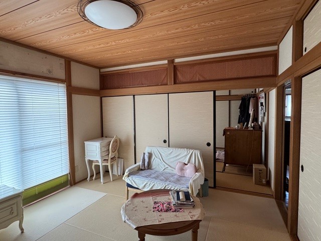 和室リフォームのBefore写真：襖の前にソファが置かれている。ソファやテーブルに布を置いて日々の暮らしを楽しんでいる様子。