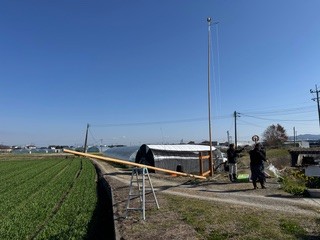 脚立を利用し、2本目の鯉のぼりの竿を準備中の様子