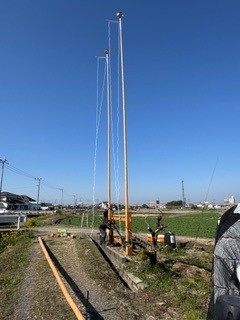 2本目の鯉のぼりの竿を人力で立てる作業の様子