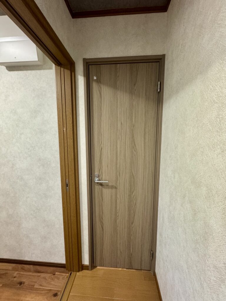 トイレドア交換後の様子｜木目調の新しいドアを設置した廊下